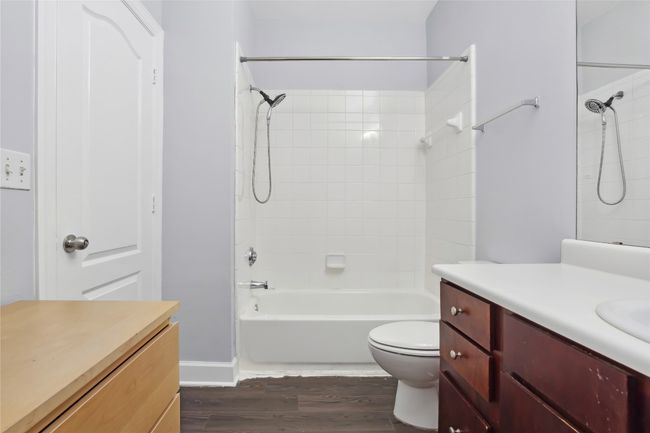 Full bath with bathing tub / shower combination, wood finished floors, vanity, and toilet | Image 21