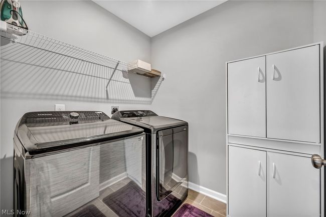 Laundry room with washer and dryer, cabinets, hookup for an electric dryer, and tile floors | Image 42