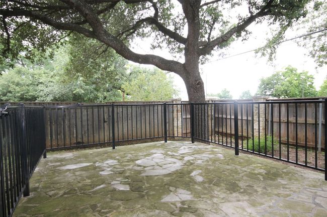 Fenced backyard with a patio | Image 19