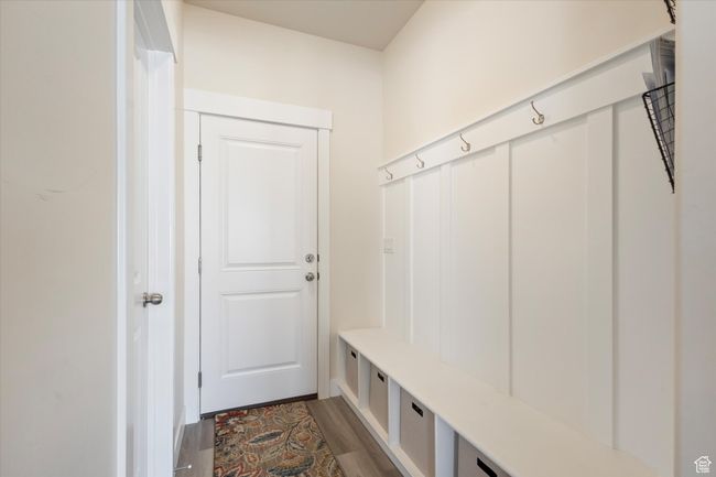 Mudroom featuring wood-style flooring, bench, and cabinets | Image 13