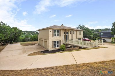 Surrounded by mature trees, the property welcomes you with an extended driveway leading to a spacious 3-car garage. | Image 3