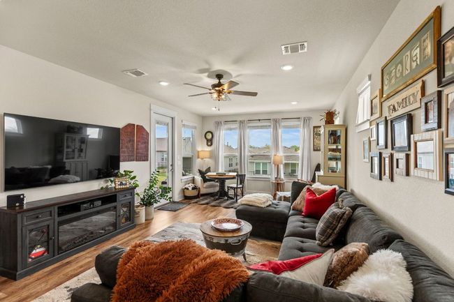 Living area with wood finished floors, visible vents, and a ceiling fan | Image 18