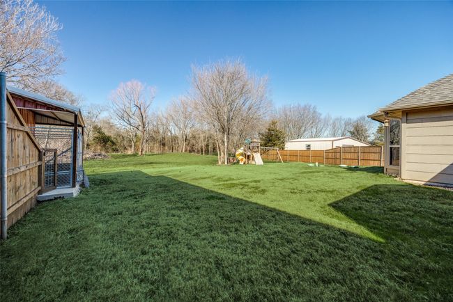 View of yard featuring a playground and an outdoor structure | Image 23