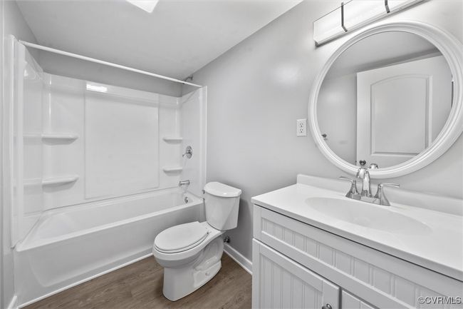 Full bathroom featuring wood finished floors, shower / bathing tub combination, toilet, vanity, and baseboards | Image 27