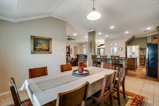 Dining space with ceiling fan, crown molding, light tile patterned flooring, and recessed lighting | Image 6