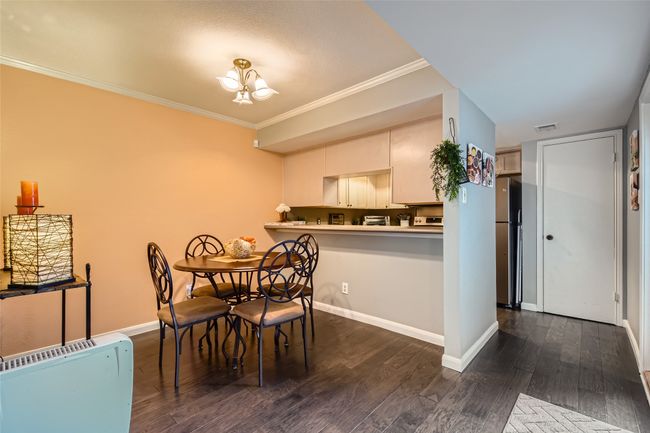 Dining space featuring dark wood finished floors, baseboards, a chandelier, and crown molding | Image 5