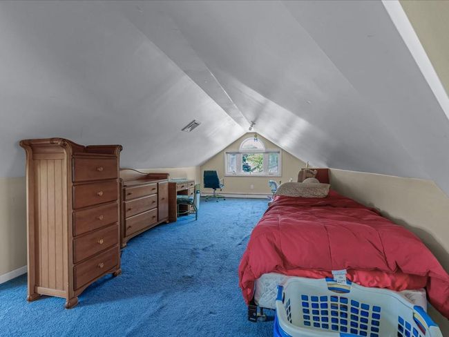 Carpeted bedroom with lofted ceiling and baseboards | Image 25