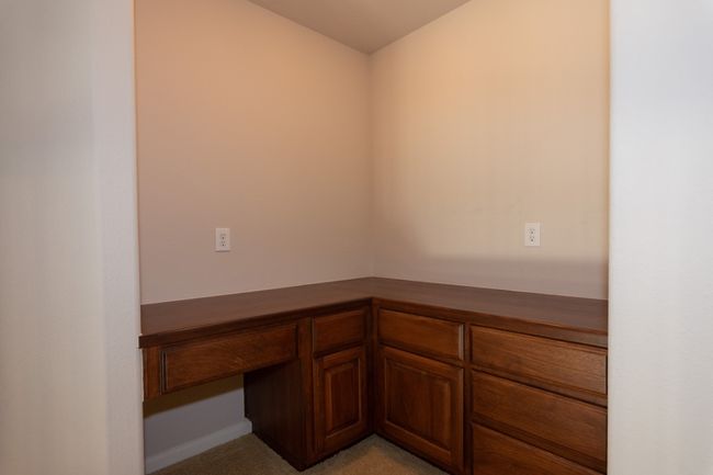 Unfurnished office with built in study area and baseboards | Image 16