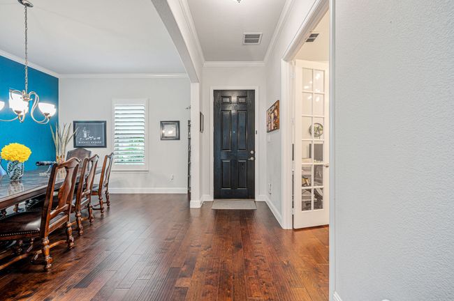 Entrance foyer with a chandelier, dark wood-style floors, and ornamental molding | Image 10
