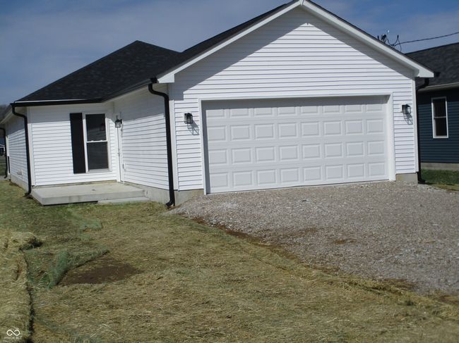 view of front of home featuring driveway, a shingled roof, and a garage | Image 25