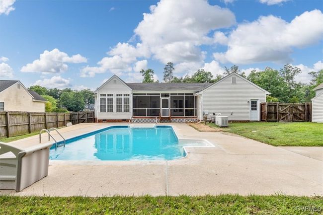 View of swimming pool featuring a sunroom, central AC unit, and a patio area | Image 4