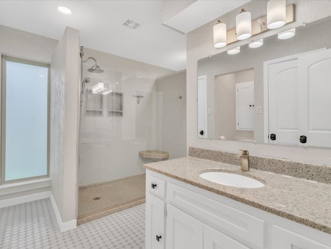 Bathroom with a walk in shower, tile patterned floors, and vanity | Image 24