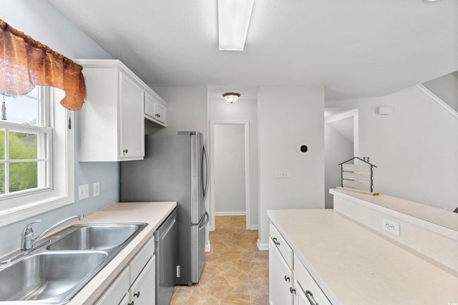 Kitchen with white cabinetry, dishwasher, and light countertops | Image 9
