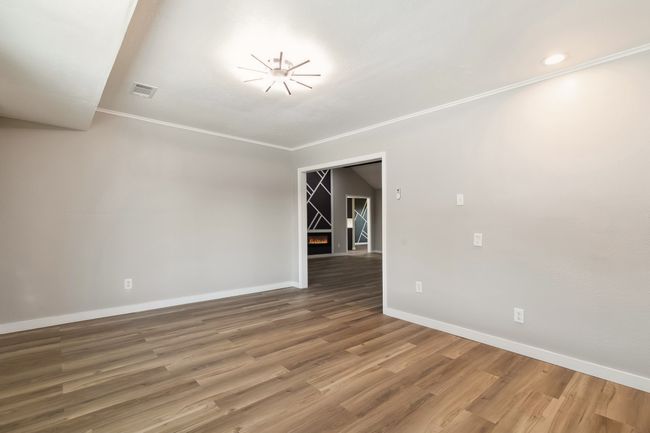 Unfurnished room featuring ornamental molding, visible vents, wood finished floors, and baseboards | Image 33