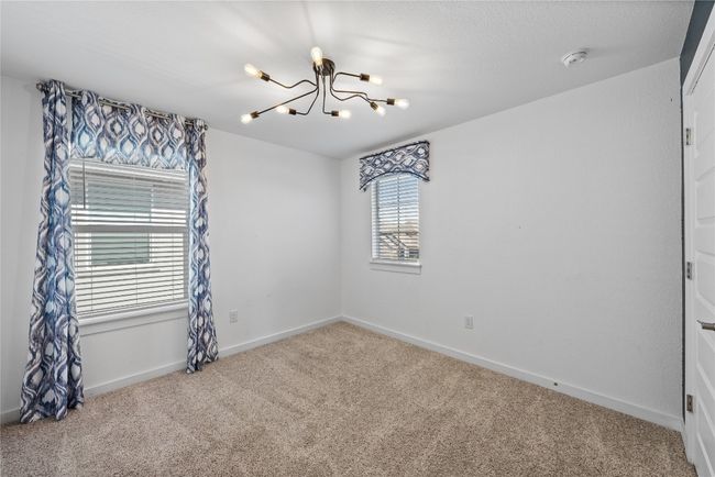Unfurnished room with baseboards, an inviting chandelier, and carpet | Image 30