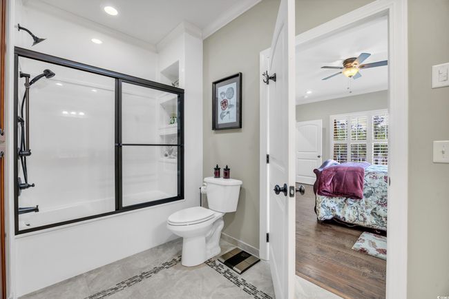 Full bath with ensuite bathroom, crown molding, combined bath / shower with glass door, toilet, and recessed lighting, custom tile | Image 20