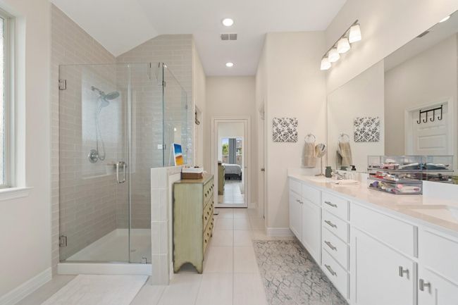 The primary bad features an oversized walk in shower, a large window allowing for an abundance of natural lighting. | Image 18