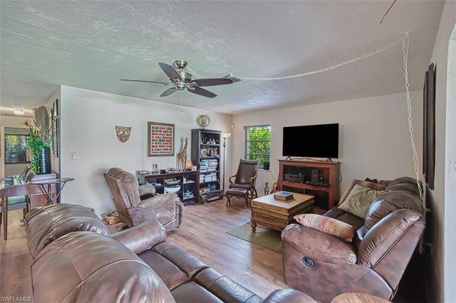 Living room featuring wood finished floors, a ceiling fan, and a textured ceiling | Image 10