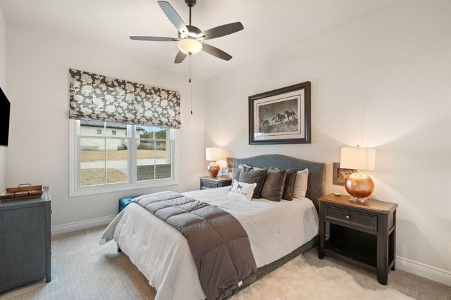 Bedroom featuring a ceiling fan, light carpet, and baseboards | Image 25