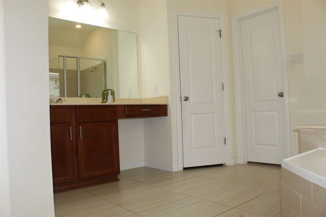 Bathroom featuring a shower stall, vanity, and tile patterned floors | Image 24