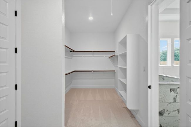 Walk in closet featuring light colored carpet | Image 15