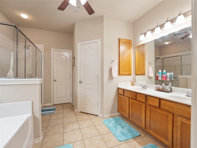 Full bathroom with ceiling fan, a shower stall, double vanity, and a garden tub | Image 18