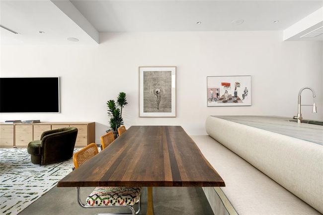 Blending comfort with design-forward detail, the dining area features a custom upholstered banquette built seamlessly into the kitchen island. Artful accents and soft neutral tones enhance the flow of this open-concept space, making it equally suited for everyday meals or stylish entertaining. | Image 14
