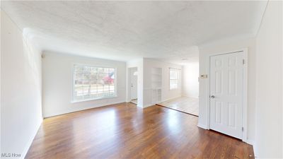 Empty room with dark wood-type flooring and a textured ceiling | Image 2