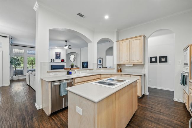 Kitchen with light brown cabinets, white appliances, a ceiling fan, light countertops, and crown molding | Image 9