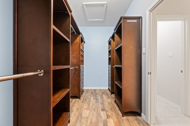Walk in closet with light wood-type flooring and attic access | Image 22