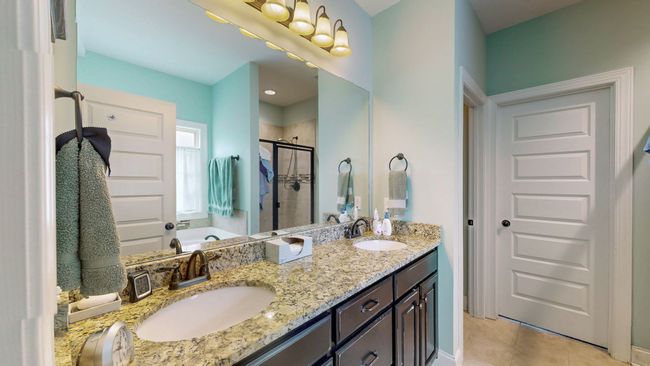 Double sinks, a tub for relaxing, and a tastefully tiled shower are features of the owner's bathroom. | Image 18