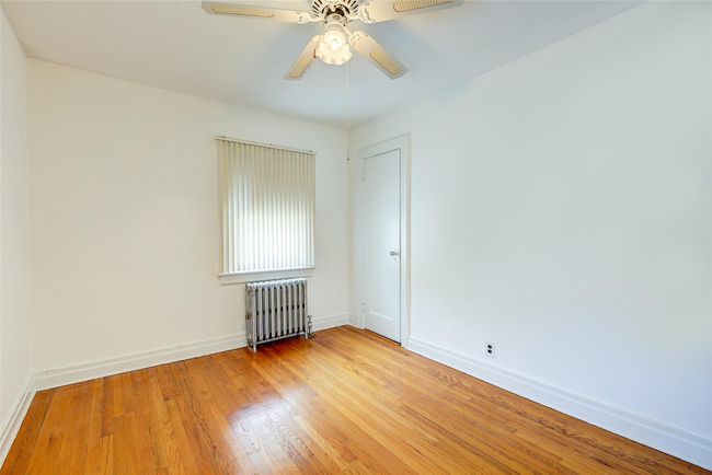 Empty room with radiator, light wood-type flooring, and ceiling fan | Image 28
