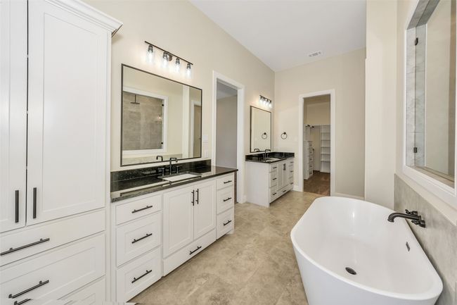 Full bathroom with visible vents, a freestanding bath, two vanities, and a sink | Image 25