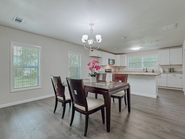 Dining room featuring wood finished floors and a chandelier | Image 7