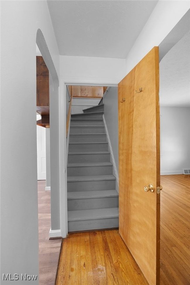 Stairway featuring arched walkways, visible vents, wood finished floors, and baseboards | Image 16