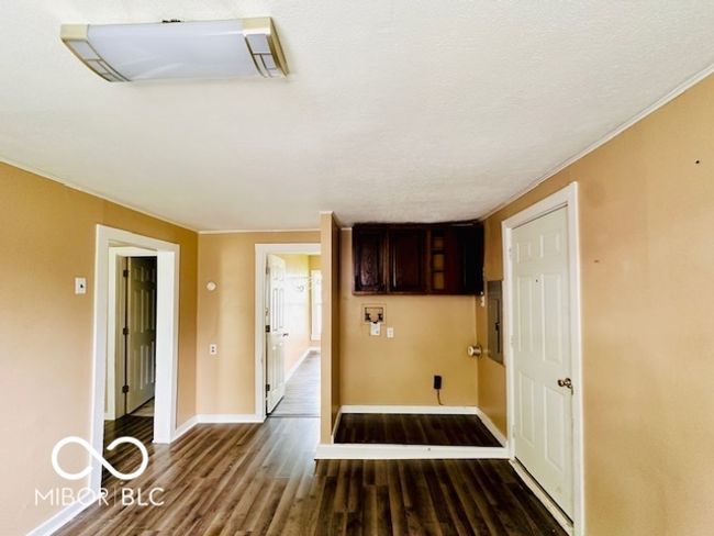 laundry area featuring wood finished floors and baseboards | Image 6