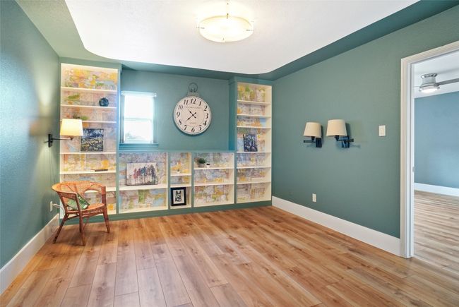 Primary bedroom, recently painted tranquil grey with a feature wall. Has ceiling fan and light hardwood / wood-style floors | Image 12