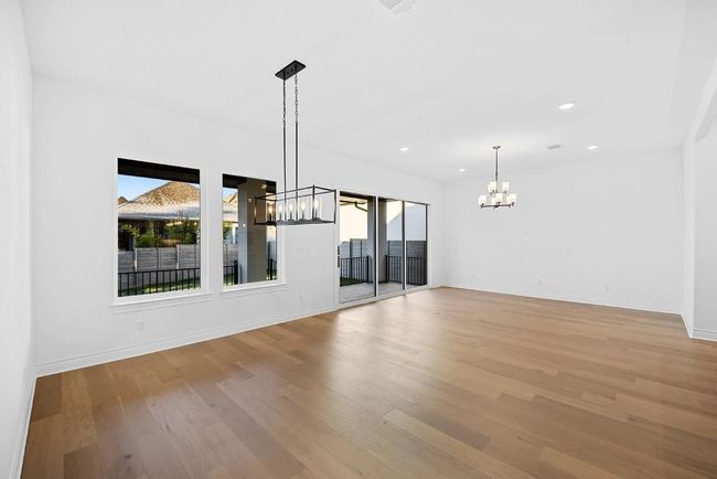 Spare room with a chandelier, healthy amount of natural light, light wood finished floors, and recessed lighting | Image 9