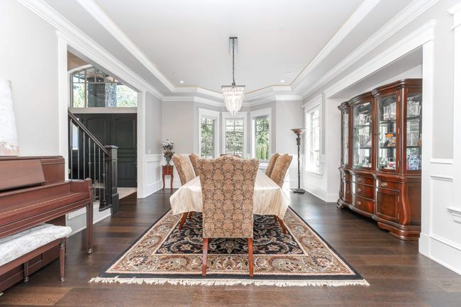 Dining area featuring a healthy amount of sunlight, ornamental molding, wood finished floors, and a notable chandelier | Image 12