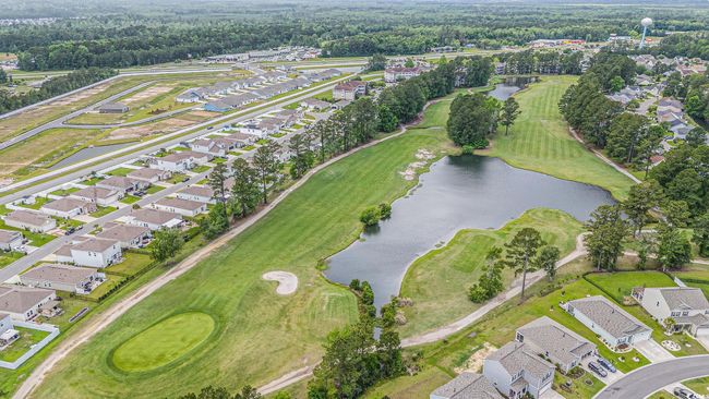 Aerial view of property and surrounding area featuring nearby suburban area, a nearby body of water, and a local golf course | Image 33