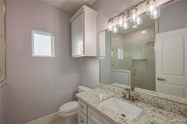 Bathroom with tile patterned floors, vanity, toilet, and an enclosed shower | Image 12