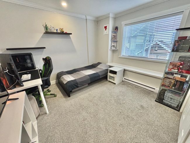 Bedroom with crown molding, baseboard heating, and carpet | Image 24