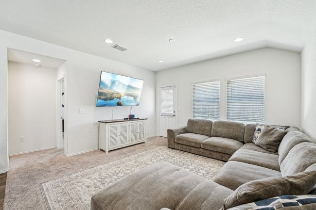 Carpeted living area with recessed lighting, visible vents, baseboards, and a textured ceiling | Image 5