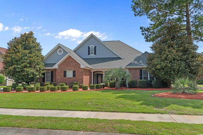 Traditional home with brick siding, a front lawn, and roof with shingles | Image 5