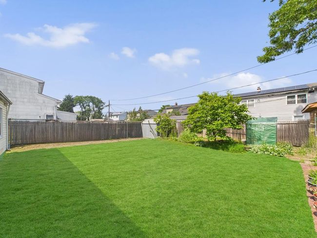 Fenced backyard with a storage unit | Image 29