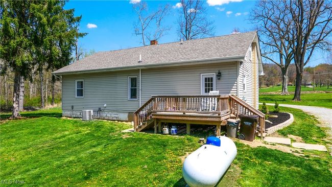 Back of property with a chimney, a deck, a lawn, roof with shingles, and stairs | Image 26