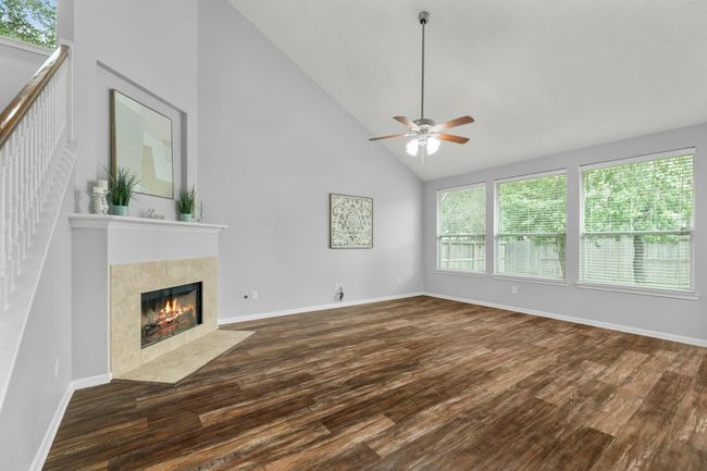 Soaring ceilings and oversized windows fill the living room with natural light, while new flooring ties the space together with warmth and style. | Image 9