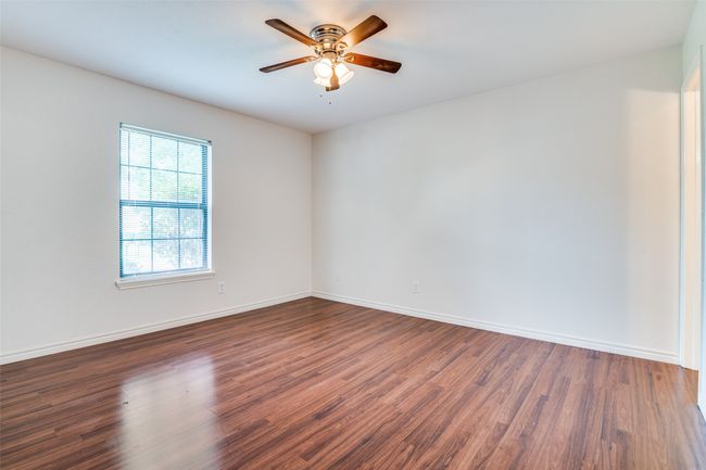 Unfurnished secondary bedroom with wood finished floors and ceiling fan. | Image 21