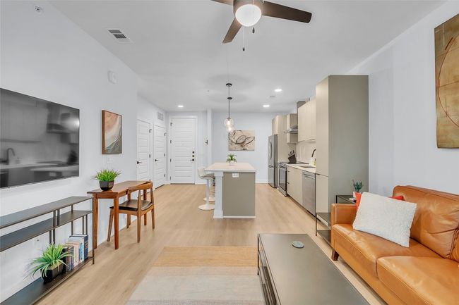 Living area with light wood finished floors, a ceiling fan, and recessed lighting | Image 11