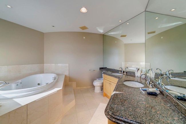 Bathroom with a whirlpool tub, visible vents, and a sink | Image 4